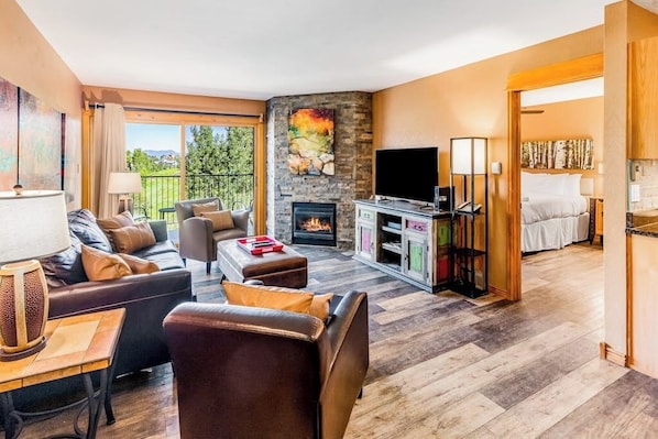 Ein modernes Wohnzimmer mit Kamin, Fernseher und einer Couch.