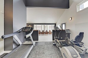 Ein Fitnessraum mit Laufbändern, einem Ergometer und einem Rudergerät.