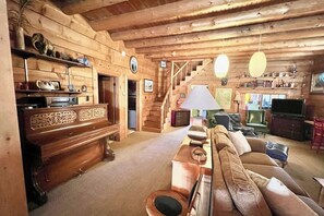 A wooden interior with a sofa, television, and a staircase. - Original charmer with expansive waterfront deck, dock, fireplace - walkable area (Grand Lake)
