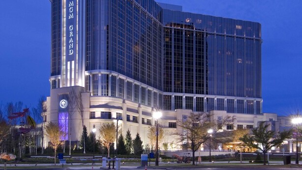 A modern hotel with a curved facade, large windows, and a prominent 'MGM GRAND' sign.