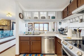 A modern kitchen with wooden cabinets, a stainless steel dishwasher, and an oven. - Mountain Getaway condo with wood burning fireplace close to adventure (Granby)