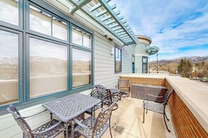 Un patio con mobiliario exterior y vistas a las montañas.