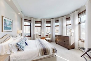 Un dormitorio con cama, mesitas de noche, cómoda y una silla.