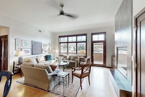Ein geräumiges Wohnzimmer mit einer Couch, Sesseln, einem Couchtisch und einem Kamin.