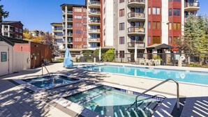 Piscina com hidromassagem, cercada por edifícios residenciais de vários andares.