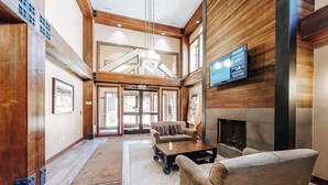 A spacious lobby with a fireplace, a television mounted on the wall, and a seating area with a coffee table.