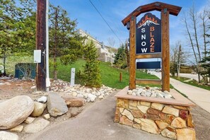 A wooden sign with 'SNOW' and 'BLAZE' text, a stone base, and a paved path leading to a building. - Studio on the Shuttle Route with WiFi and Shared Pool, Hot Tubs, and Gym (Winter Park)
