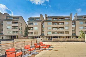 A multi-story hotel with a rooftop terrace featuring outdoor seating and a view of the surrounding area. - Studio on the Shuttle Route with WiFi and Shared Pool, Hot Tubs, and Gym (Winter Park)