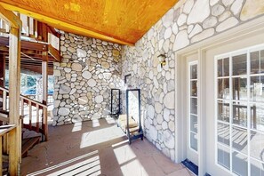 Ein Innenraum mit Steinwänden, Holzboden und einer Tür mit Fenster.