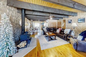 Ein gemütliches Wohnzimmer mit Kamin, einer Couch, einem Couchtisch und einem Weihnachtsbaum.