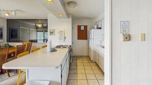 A compact kitchen with white cabinets, a central island, and a dining area with chairs. - Mountain & lake views from this Lake Cliffe condo - clubhouse access (Dillon)