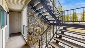 A staircase leading to a balcony with a stone wall and a metal railing. - Mountain & lake views from this Lake Cliffe condo - clubhouse access (Dillon)
