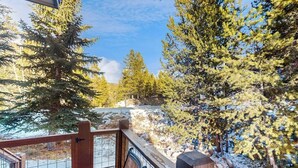 A wooden deck with a metal railing overlooking a snowy landscape with trees. - End-Unit Townhome on Shuttle Route w/WiFi/Shared Pool/Hot Tub - 1 Mile to Slopes (Keystone)