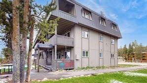 Ein mehrstöckiges Gebäude mit Balkon, Treppe und flachem Dach.