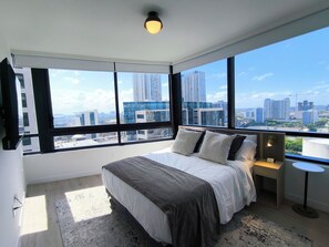 A bedroom with a large window, a bed, a bedside table, and a lamp. - D2102 - Modern Skyline Corner Suite with Pool & Gym in Downtown Miami (Miami)