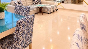 Un salon moderne avec une grande fenêtre, un canapé, une table à manger et un lustre.