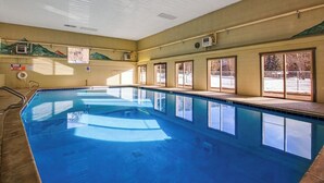 A large indoor swimming pool with clear windows, a tiled floor, and a ceiling with ventilation. - Mountain view condo w/ a shared pool, hot tub, Ping-Pong, & pool table (Dillon)