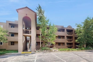 A multi-story building with a central staircase, balconies, and a parking lot. - Wildernest Condo Close to Top Ski Resorts  + Free WiFi (Silverthorne)