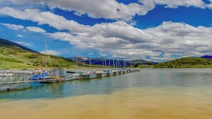 Ein Yachthafen mit vertäuten Booten, einem klaren Himmel und Bergen im Hintergrund.