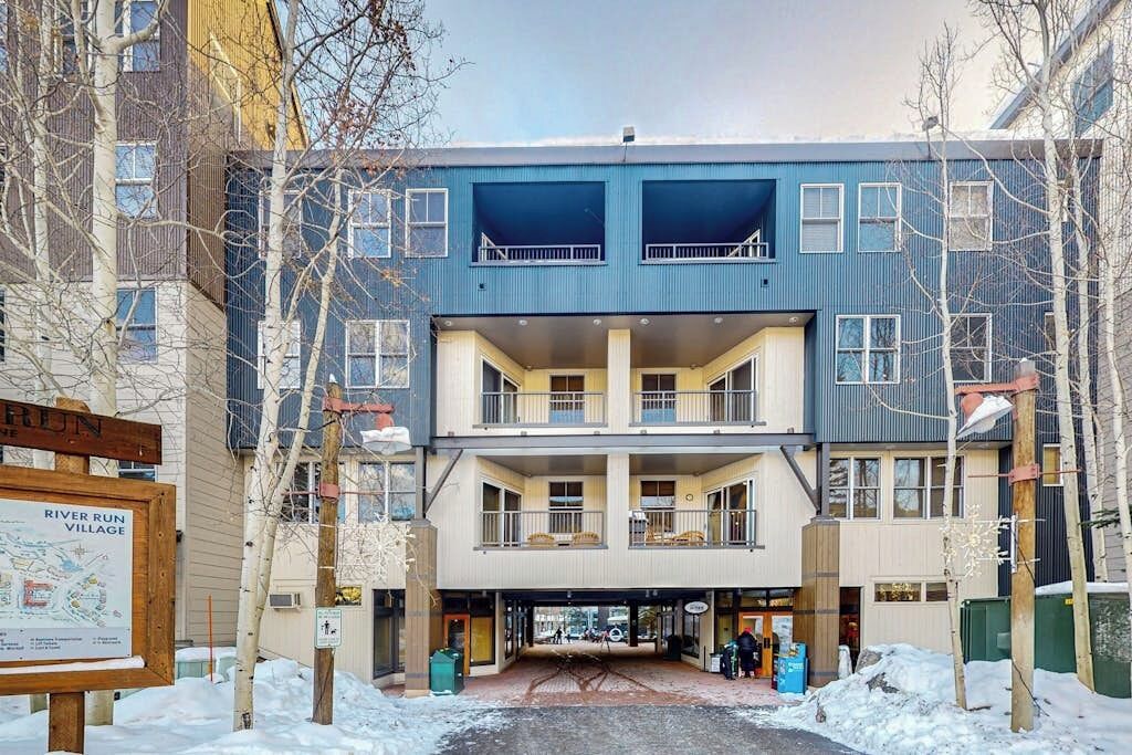 A multi-story building with balconies, a signboard, and a covered entrance.