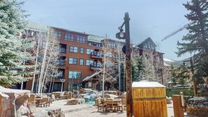 A building with multiple floors, outdoor seating, a wooden structure, and a water feature. - Ski-In/Out Condo with Shared Pool, Hot Tub & Sauna - Walk to Village (Keystone)