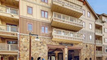 Un edificio de varios pisos con balcones, fachada de piedra y un letrero que dice 'Red Hawk'.