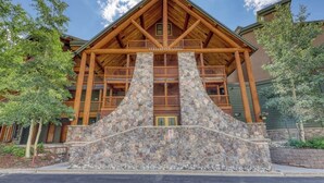 A lodge with a stone facade, wooden balconies, and a prominent entrance. - Cozy condo with shared hot tub & private deck- close to the slopes (Keystone)