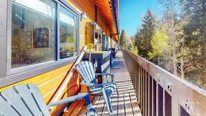 A wooden deck with Adirondack chairs, a wooden railing, and a view of trees. - 2nd-floor chalet with fireplace, grill, balcony, washer/dryer, ski & mtn views (Vail)