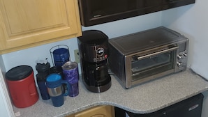 Eine kleine Küche mit einer Mikrowelle, einem Toaster und einer Kaffeemaschine auf der Arbeitsfläche.