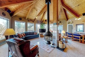 Ein gemütliches Wohnzimmer mit Kamin, Ledersofa und Holzbalken.