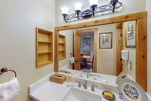 A bathroom with a large mirror, a sink, a toilet, and a shower area. - Large, inviting home with fabulous valley views, hot tubs & grills (Steamboat Springs)