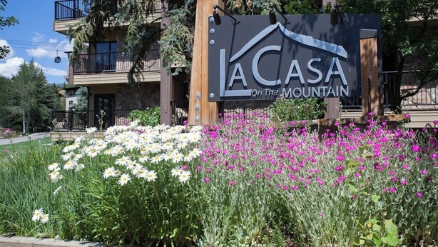 Ein Schild mit der Aufschrift 'LA CASA On The Mountain', im Hintergrund ein Gebäude.