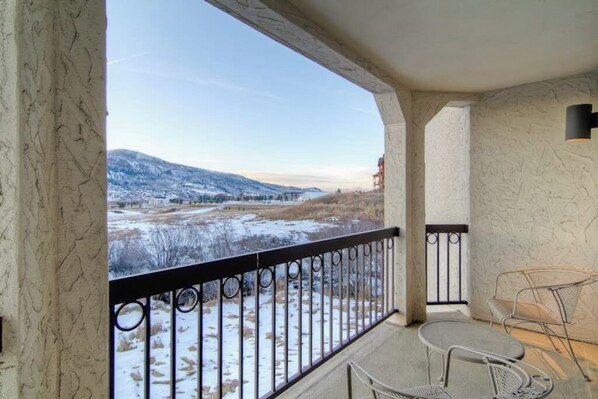 A balcony with a metal railing, a small table, and two chairs. - Comfortable Condo w/ Shared Pool, Gym, Hot Tub, Winter Shuttle, & Ski Lockers (Steamboat Springs)