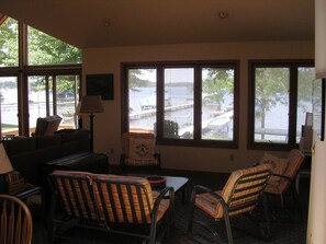 A room with a view of a body of water, a sofa, chairs, and a lamp. - Lake life starts here! (Dowagiac)