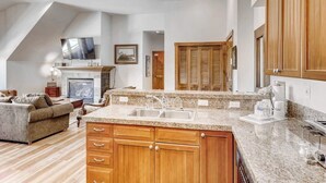 A spacious kitchen with granite countertops, wooden cabinets, and a built-in oven. - In-town condo with hot tubs, pool, gym & sauna - steps to lifts & Main Street (Breckenridge)