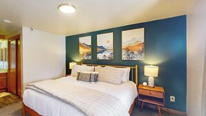 Ein Schlafzimmer mit Bett, Nachttischlampen und Bildern an der Wand.