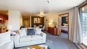 Ein Hotelzimmer mit Sofa, Essbereich, Küche und einem Bett.