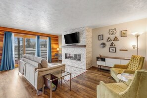 Ein Wohnzimmer mit Kamin, Fernseher und einer Couch.