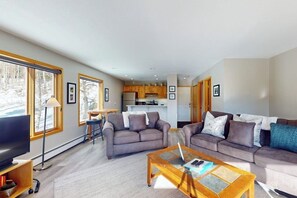 Ein Wohnzimmer mit zwei Sofas, einem Couchtisch und einem Fernseher.