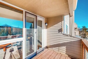 Ein Balkon mit Blick auf einen Berg, eine Schiebetür und ein Holzboden.