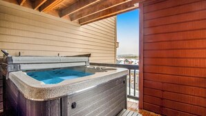 A hot tub on a wooden deck with a view of buildings in the background. - Home with hot tub, gas fireplace, and garage (Silverthorne)