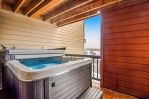 A hot tub on a wooden deck with a view of buildings in the background. - Home with hot tub, gas fireplace, and garage (Silverthorne)