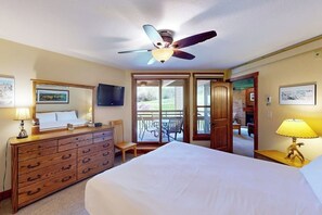 Ein Hotelzimmer mit Bett, Schminktisch, Deckenventilator und Blick ins Freie.
