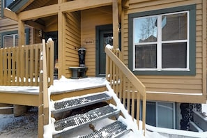 Ein Holzhaus mit Veranda, Treppe und Fenster.