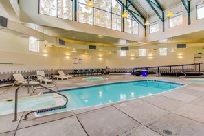 Ein großes Hallenbad mit Liegestühlen und einer Sonnenterrasse.