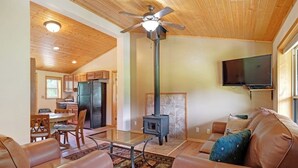 A living room with a sofa, a coffee table, a fireplace, and a television.