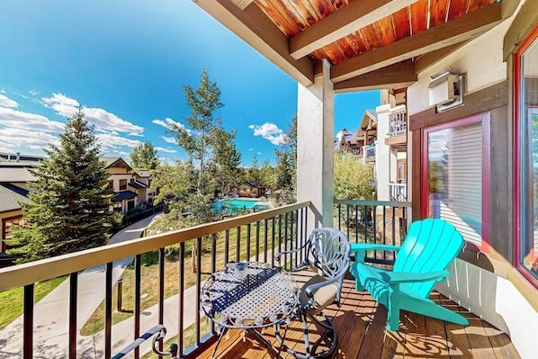A balcony with a table and chairs, a view of neighboring houses, and a clear sky. - Walk to the Gondola Enjoy a Fireplace, W/D, Shared Hot Tubs, Pool, & Shuttle (Steamboat Springs)