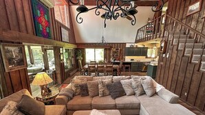 Un salon confortable avec un canapé d’angle, un coin repas et un escalier.