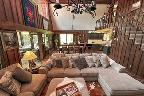 Ein gemütliches Wohnzimmer mit einer Eckcouch, einem Essbereich und einer Treppe.