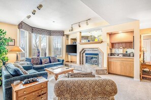 Ein Wohnzimmer mit Kamin, einer Couch, einem Couchtisch und einem Fernseher.